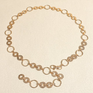 Gold chain necklace on a beige background